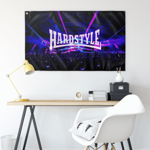 Black concert rave flag hung above a desk with yellow lamp and white chair