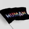Black HUMAN flag waving on a pole showing rainbow striped lettering