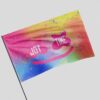 Rainbow tie-dye rave flag with pink smiley face waving on a pole close-up