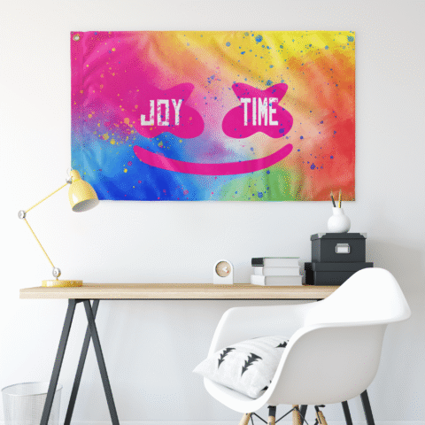 Rainbow splatter rave flag with pink smiley face hung above a desk setup