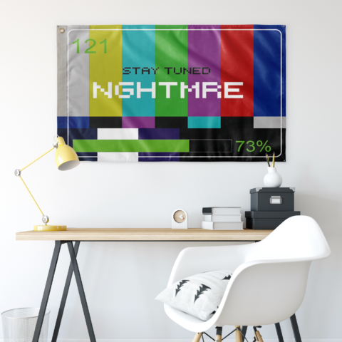 SMPTE rainbow test pattern flag hung above a desk in a bright room