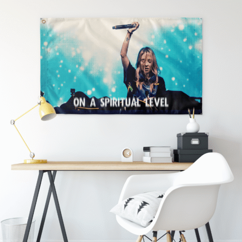 Teal turquoise rave flag hung on wall above a desk with yellow lamp