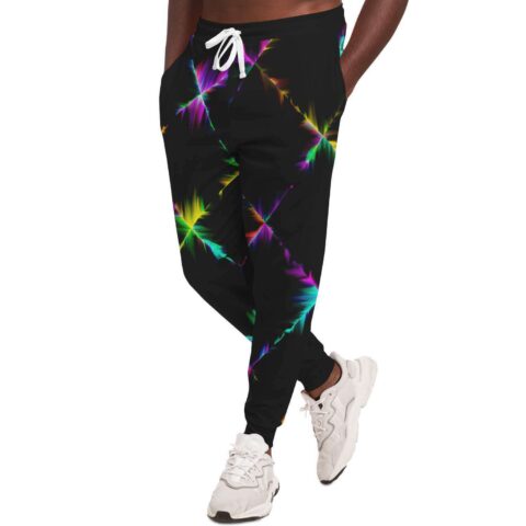 Model wearing black joggers with prismatic starburst print paired with white sneakers