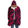 Man wearing hot pink swirling liquid rave cloak with hood on and hands in pockets