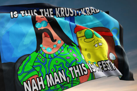 Festival flag waving shows green paisley print figure and yellow cartoon face with red headband