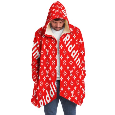 Front view of model wearing red monogram print hooded cloak with cream sherpa lined hood
