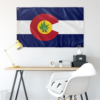 Colorado state rave flag with cannabis leaf mascot hung above a desk as wall decor