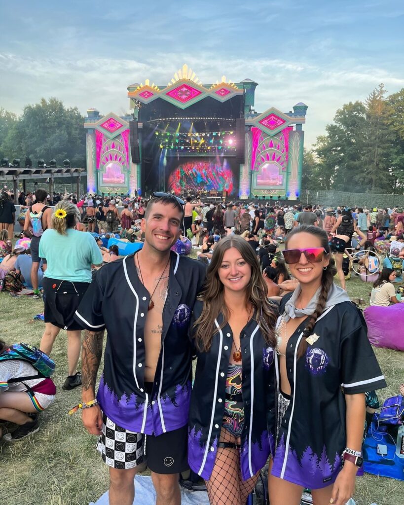 Three people posing for a picture at a music festival wearing Custom Rave jerseys