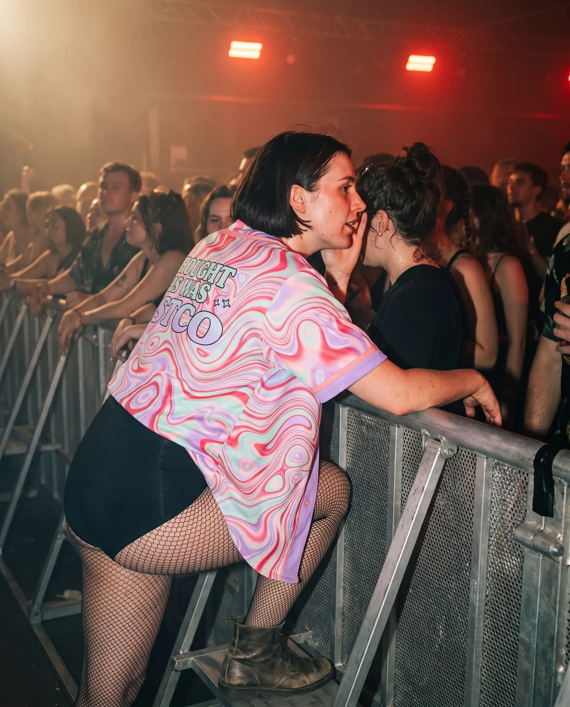 Woman wearing an open pastel baseball jersey over a bodysuit at a rave