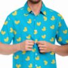 Model buttoning the blue rave button-down shirt with bright duck print