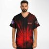 Man wears red and black radial burst baseball jersey with hieroglyph accents, front view