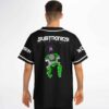 Model wearing black jersey back with neon green skeleton creature and dripping lettering, rear view