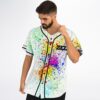 Model adjusts a rainbow paint-splatter jersey, highlighting black piping and colorful front pattern