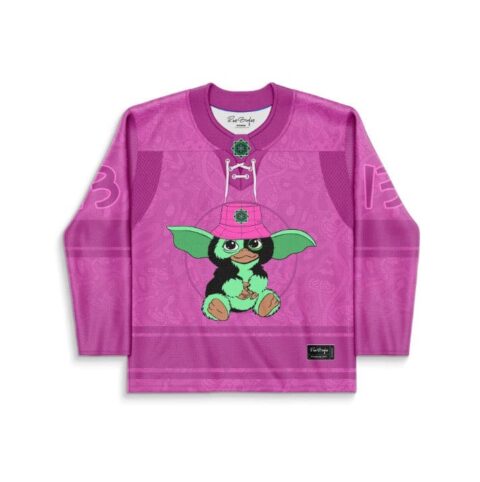 Cartoon-style green creature on a magenta tonal pattern jersey, front view with lace-up collar