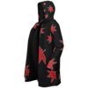 Side view of black hooded cloak with scattered red maple leaves and full-length zipper