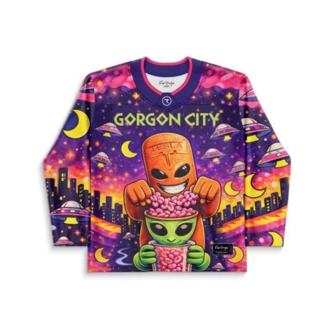Neon alien cityscape pattern with flying saucers, crescent moons, and grinning orange creature, front view