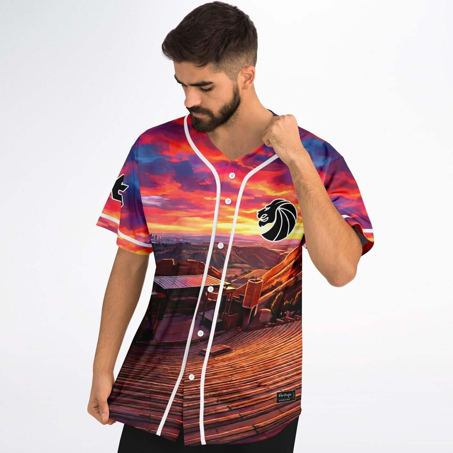 Fiery sunset landscape front jersey modeled with lion emblem, white piping, and button closure