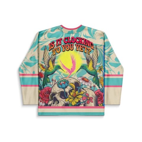 Cream-teal abstract swirl jersey, floral skull, hummingbirds, back text “IS IT CLOCKING TO YOU YET?”