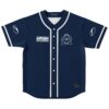 Navy front jersey with white geometric emblem, button placket, contrasting piping, flat lay view