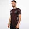 Seven Lions text and lion chest emblem on maroon rave soccer jersey, side view on model