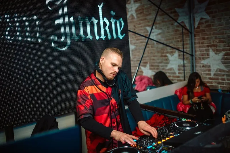 DJ at the decks wearing a red geometric custom jersey
